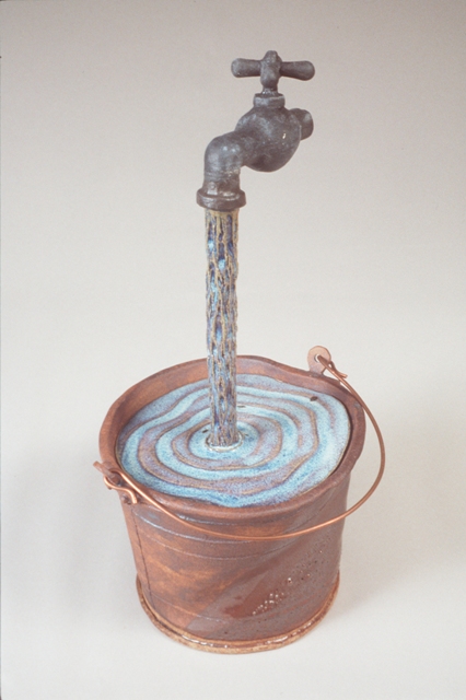 Water running into a bucket from a faucet