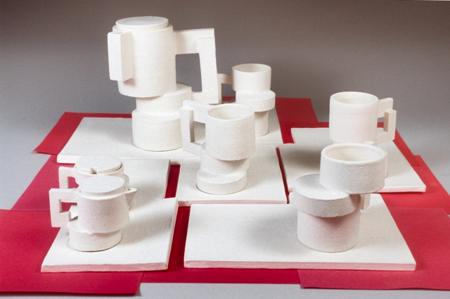 Seven piece white sculptural teapot set on red washi paper