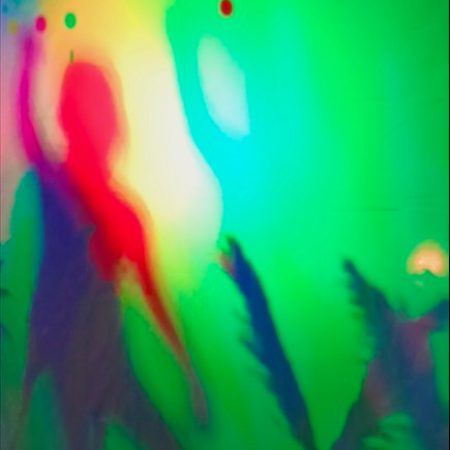 A little girl dancing in a colorful shadow installation.